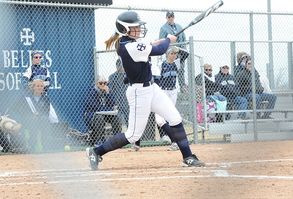 JoAnna Keilman swings at a pitch with several people visible in the background. 